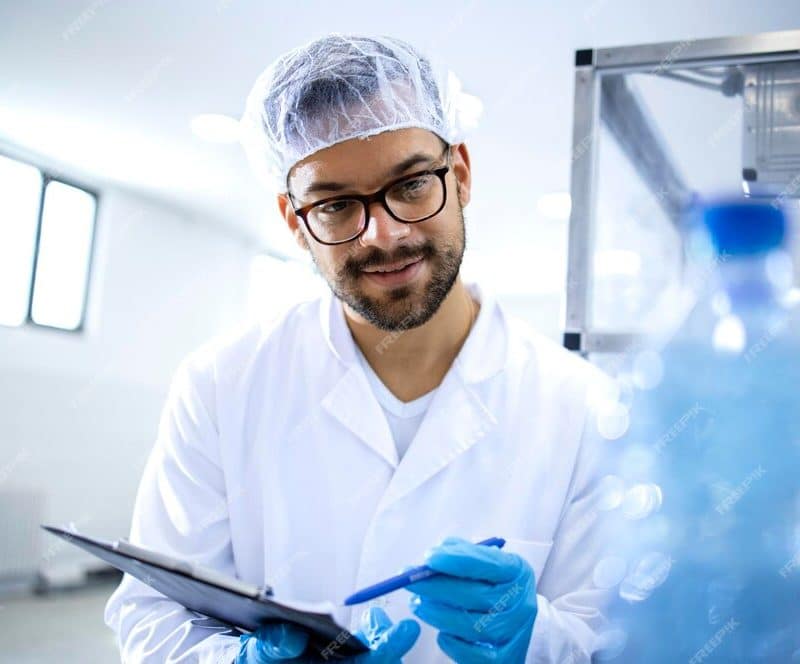 factory-worker-with-check-list-doing-quality-control-drinking-water-bottling-plant